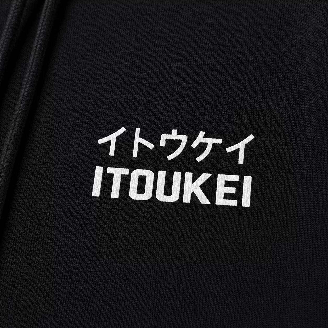 Hoodie ITOUKEI noir et blanc — détail logo poitrine