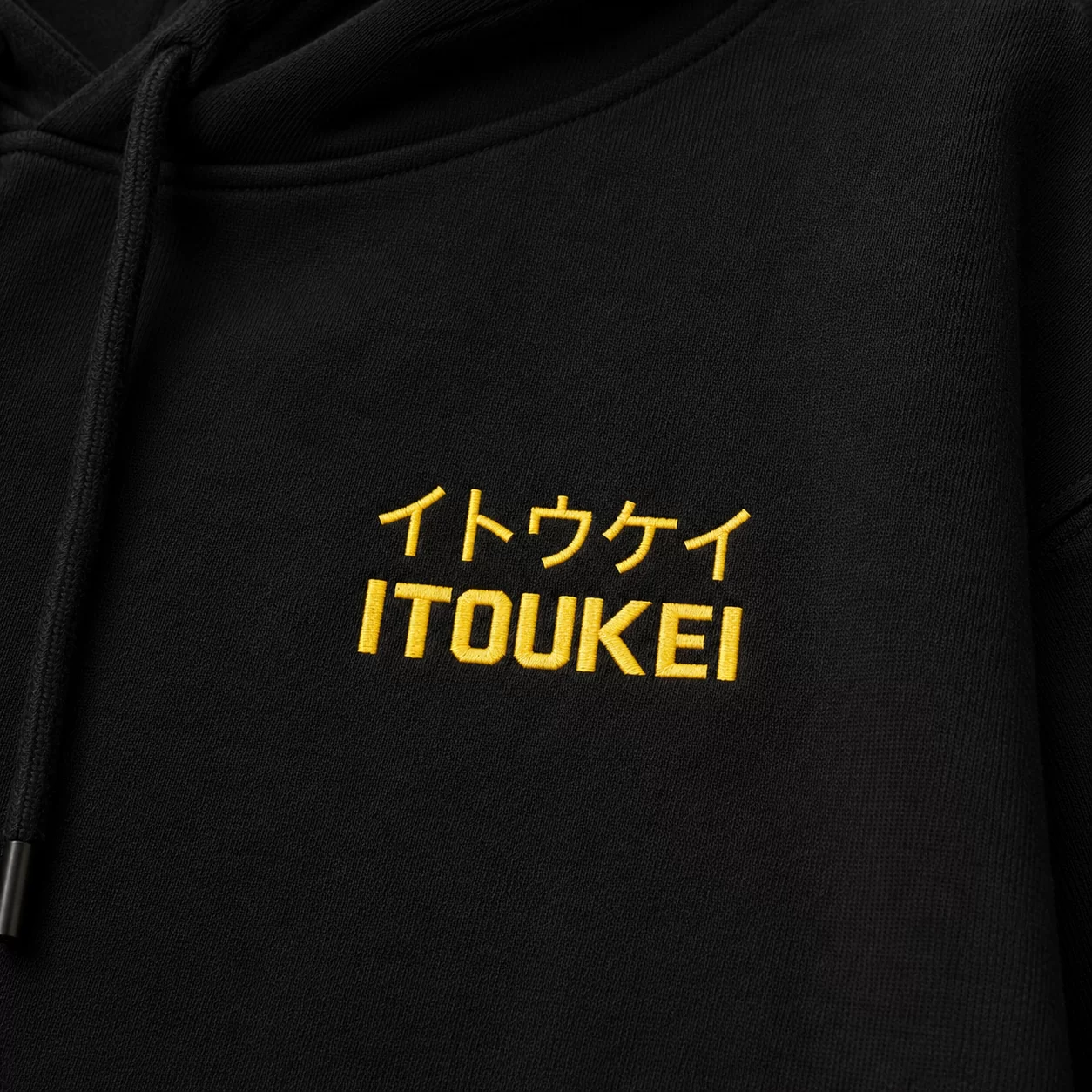 Hoodie ITOUKEI noir et jaune — détail logo poitrine